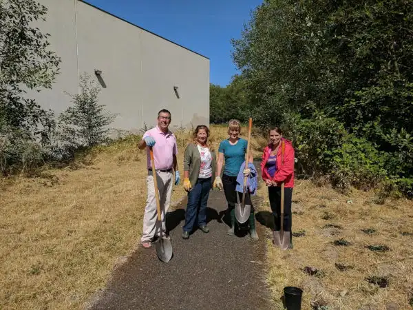 Team holding shovels at shrub planting for community service at Snohomish Conservation District