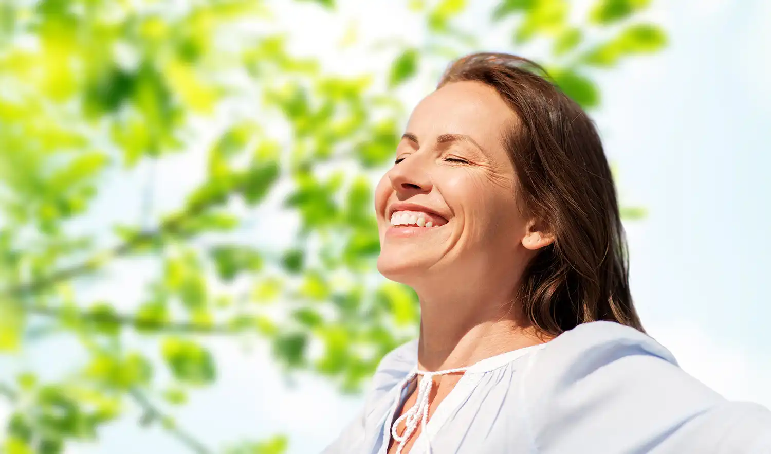 Woman smiling with eyes closed and face up in the sunlight
