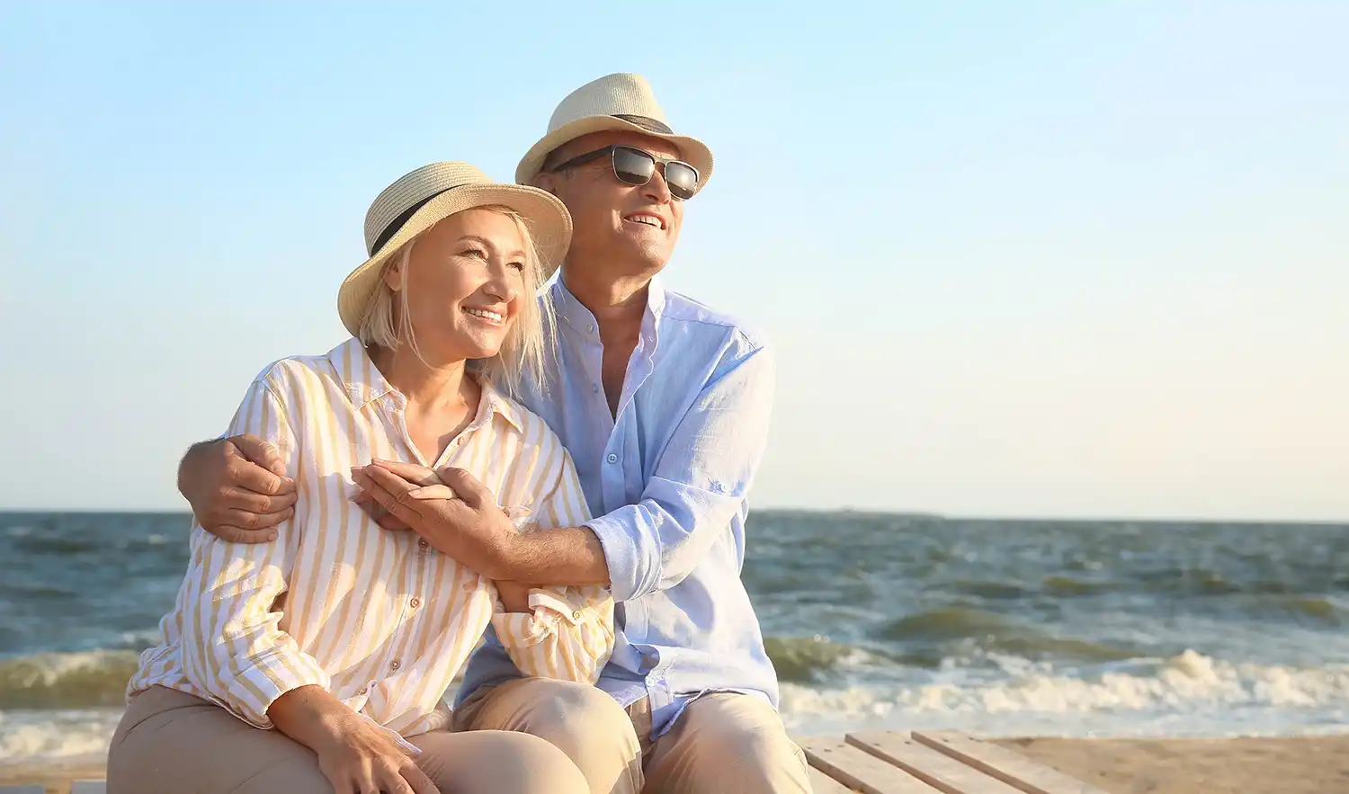 A man and woman hugging on the beach