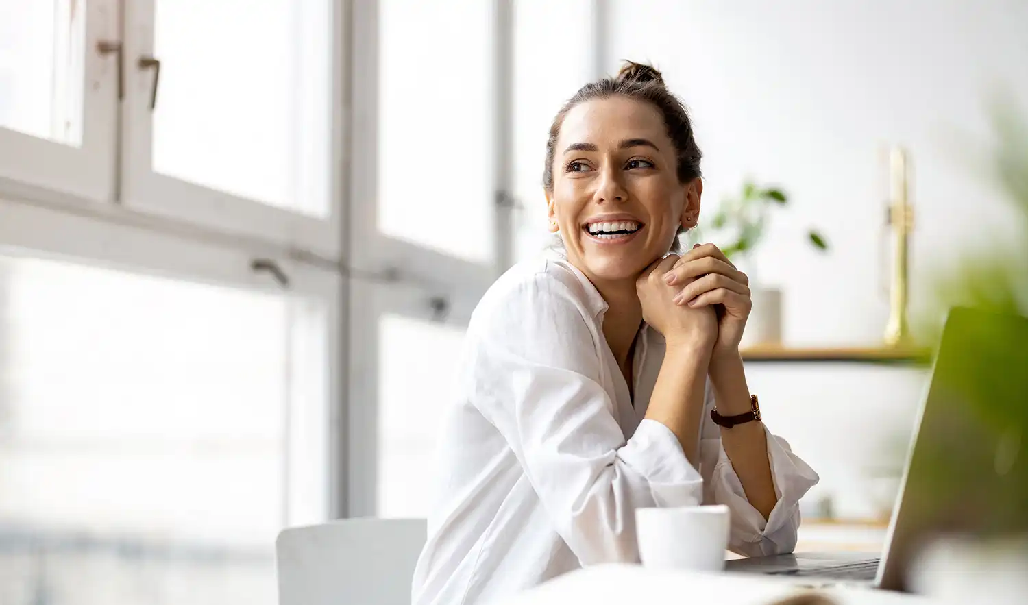 Woman smiling at desk in front of laptop