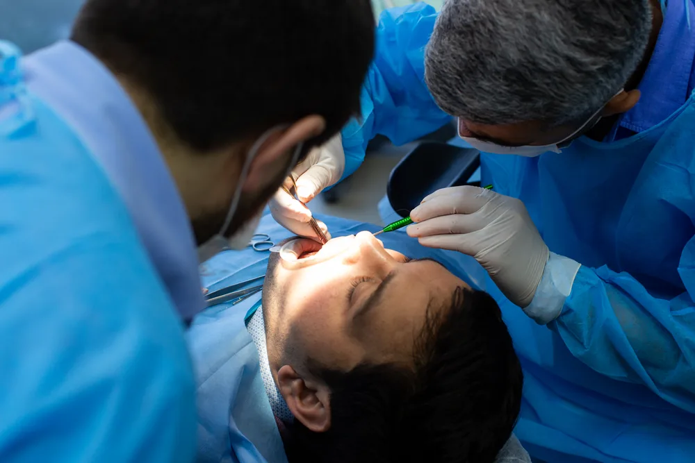 Dental team performing a root canal procedure on a patient